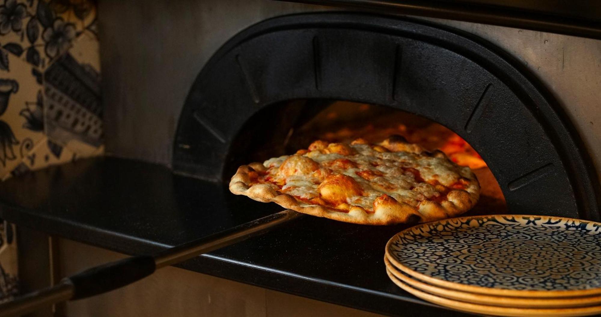 Eme Catedral Mercer Hotel Sevilha Exterior foto Pizza being removed from a wood-fired oven